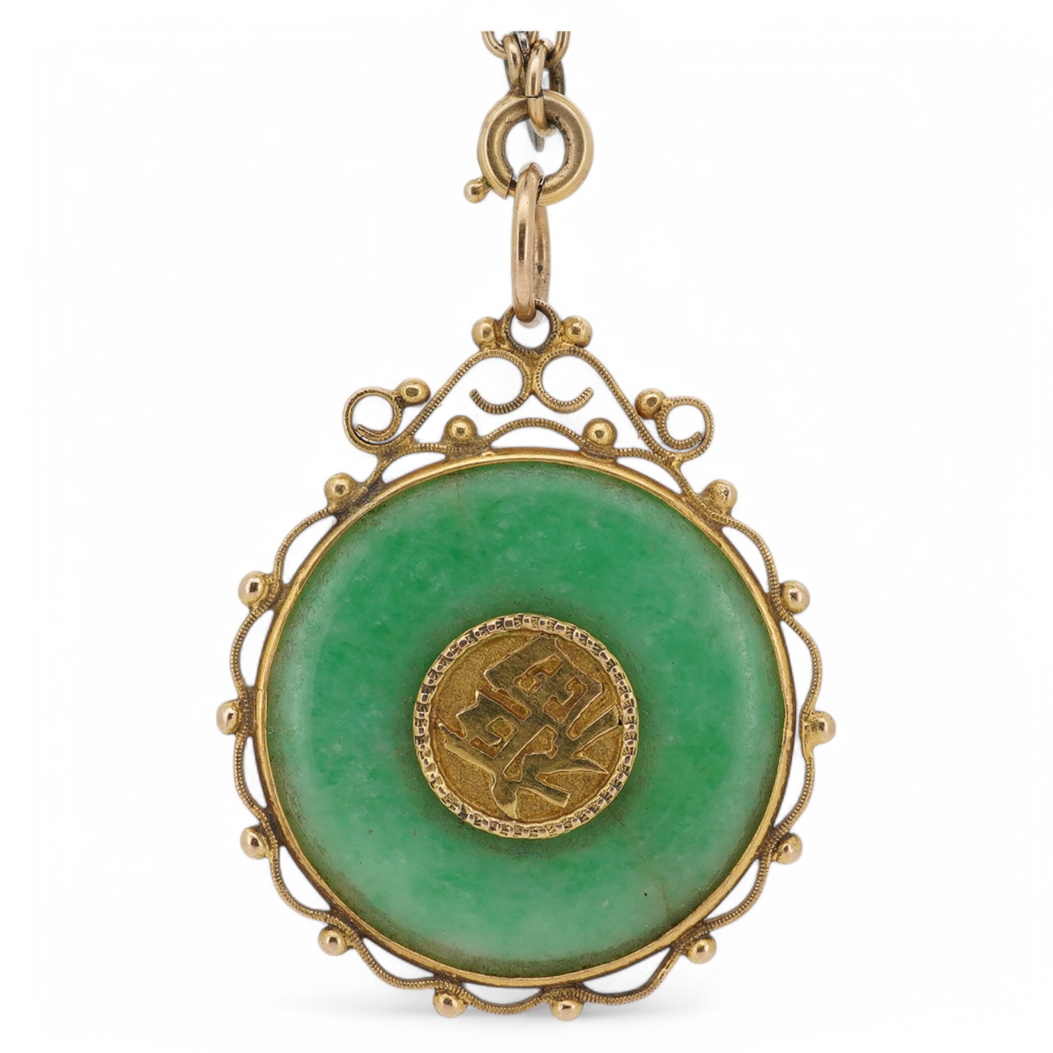 A Chinese yellow metal mounted carved jade 'Shou Fu' pendant, 36mm, on a gilt metal chain. Condition - fair to good